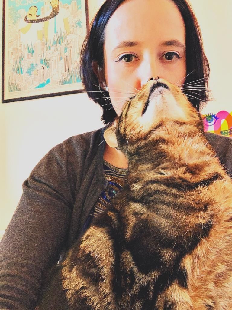 A tabby cat nuzzling up to Hilary's face